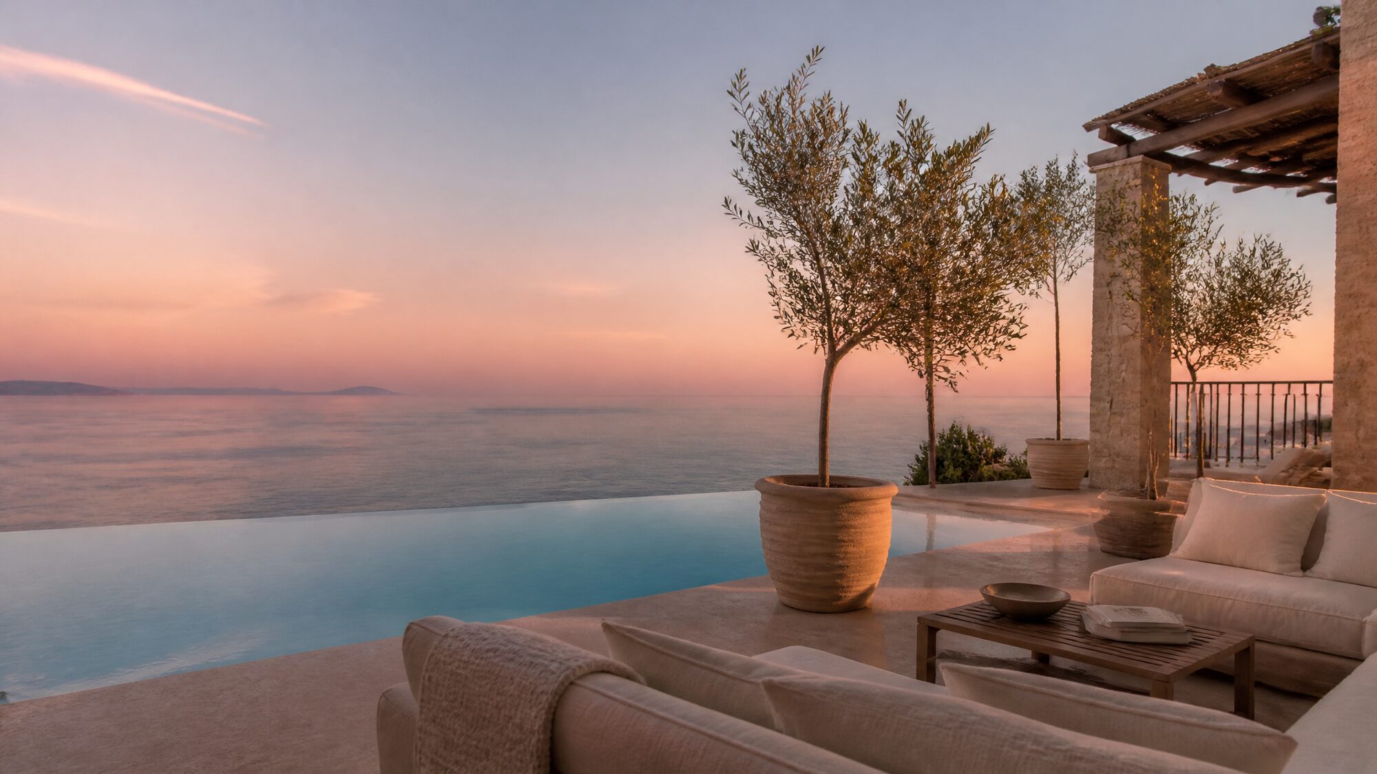 Boutique Mediterranean hotel terrace at dawn overlooking the coastline.